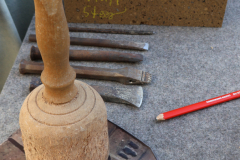 Das Material: Eisen, Klöppel, Werkstein, Schablone und Stift