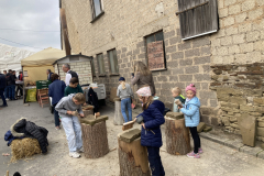 Kinder bei der Arbeit mit Klöppel und Eisen.